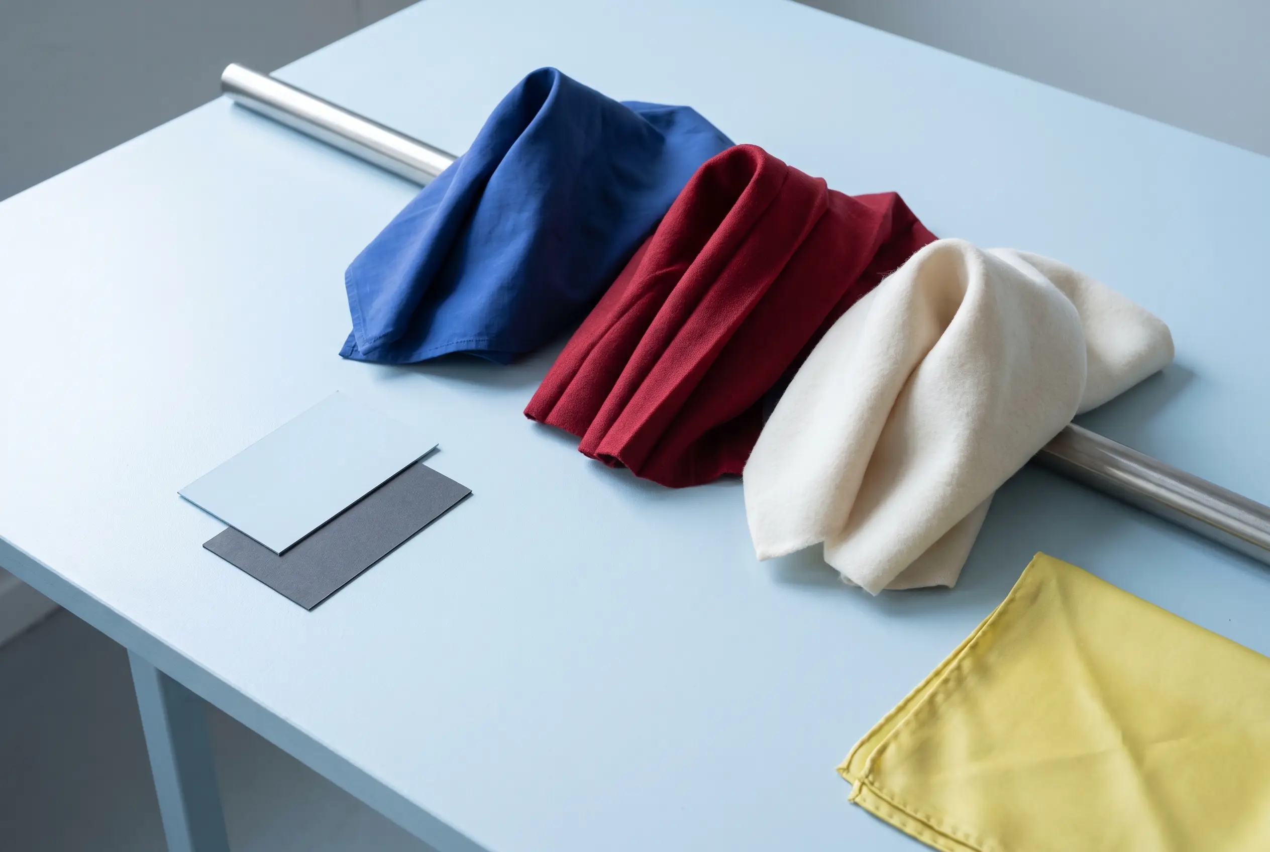 Blue, pomegranate and ivory fabrics arranged as a colour and material study